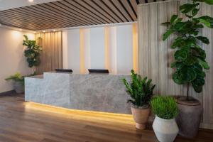 a lobby with a reception desk with potted plants at The Clara Hotel Plano, Tapestry Collection by Hilton in Plano +38 photos