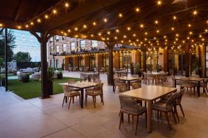 a patio with tables and chairs and lights at The Clara Hotel Plano, Tapestry Collection by Hilton in Plano