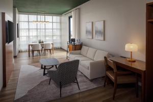 a living room with a couch and a table at The Clara Hotel Plano, Tapestry Collection by Hilton in Plano