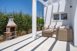 a patio with a couch and a fire place at Villa de Amigos in Cala en Porter +14 photos