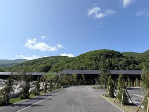 an empty road with a bridge and mountains in the background at らうす餐荘 in Rausu
