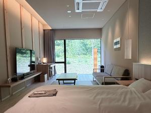 a bedroom with a bed and a living room at らうす餐荘 in Rausu