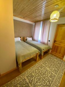 a bedroom with two beds and a window and a rug at Sarala Resort in Ostrov Kayrak