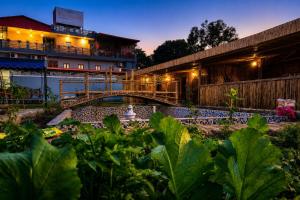 a hotel with a garden in front of a building at The Ushmaya Lifestyle Wellness Resort Near Rishikesh in Haridwār