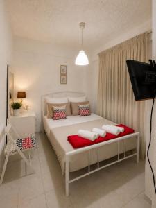 a bedroom with a bed with two pillows and a television at NiRa house in Pefkochori