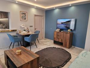 a living room with a table and a tv on a wall at Miradi Art Apartment in Stara Zagora