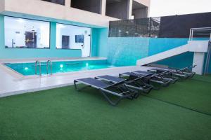 a pool with lounge chairs next to a swimming pool at Airport Chalet مزرعة وشاليه المطار in Amman