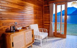 a room with a tv and a chair and a window at The Dewi Tasik Kintamani Cabin and Villa in Kubupenlokan
