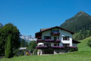 a house with flowers on the side of a hill at Berghof am Schwand in Hinterhornbach