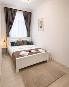a bedroom with a large white bed with a window at Mid Ultra Central Apartments, Self Check In in Oradea