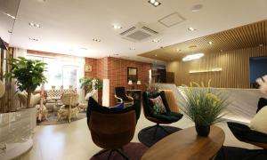 a large living room with chairs and a couch at De Lamour Hotel in Tongyeong