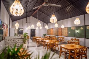 a restaurant with wooden tables and chairs and lights at The Dewi Tasik Kintamani Cabin and Villa in Kubupenlokan