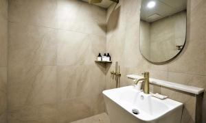 a bathroom with a sink and a mirror at De Lamour Hotel in Tongyeong +27 photos