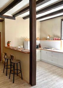 a kitchen with a counter and stools in a room at La P'tite Bouriane in Le Vigan