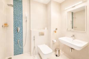 a bathroom with a toilet and a sink and a shower at Avyanna Gulhi Beach Hotel in Gulhi +37 photos