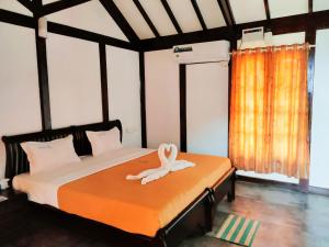 a bedroom with a bed with a towel on it at Blue Water Beach Resort in Varkala