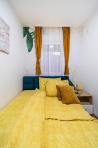 a bedroom with a large bed with a yellow blanket at Dream Apartment in Vrnjačka Banja