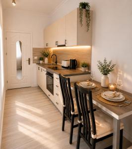 a kitchen with a table with chairs and a counter top at Mid Ultra Central Apartments, Self Check In in Oradea