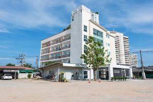 a large white building with a tree in front of it at Le Nara Residence in Jomtien Beach