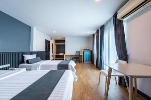 a hotel room with two beds and a table at Le Nara Residence in Jomtien Beach