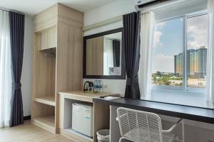 a room with a desk and a large window at Le Nara Residence in Jomtien Beach