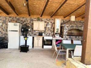 a kitchen with white appliances and a table in it at Apartmani Vukotić in Budva