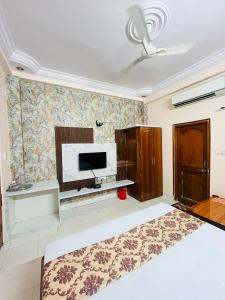 a bedroom with a bed and a flat screen tv at Hotel Natraj Palace in Seonī