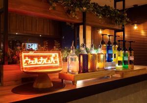 a bar with a display of bottles on a counter at Super Hotel Minami Hikone Ekimae in Hikone