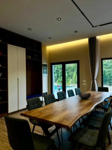 a dining room with a large wooden table and chairs at Aries Villa Albania in Vorë +61 photos