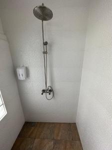 a bathroom with a shower with a light on the wall at Bangkok Sleep Nest in Sathani Ban Hua Mak