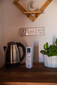 a tea kettle sitting on a counter next to a microwave at Wild Roots Cabana Arugambay in Arugam Bay