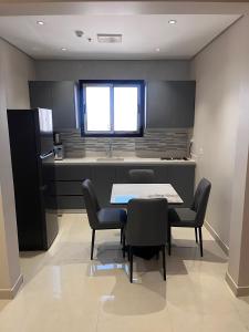 a kitchen with a table and chairs and a sink at جودول للشقق المخدومة in Khafji