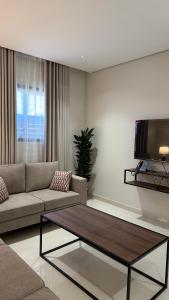 a living room with a couch and a coffee table at جودول للشقق المخدومة in Khafji
