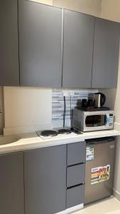 a kitchen with white cabinets and a microwave on a counter at جودول للشقق المخدومة in Khafji
