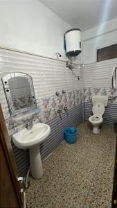 a bathroom with a sink and a toilet and a mirror at Whitestone PULGA in Kalgha