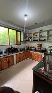 a large kitchen with wooden cabinets and windows at Whitestone PULGA in Kalgha