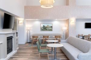 a living room with a couch and tables and a fireplace at Hampton Inn & Suites Berkshires-Lenox in Lenox