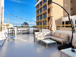 a balcony with couches and tables on a building at Swift Hostel Limassol in Limassol