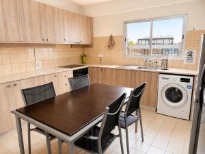 a kitchen with a table and chairs and a sink at Swift Hostel Limassol in Limassol