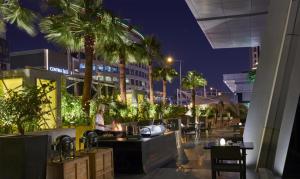 a restaurant with tables and palm trees at night at Hyatt Regency Riyadh Olaya in Riyadh