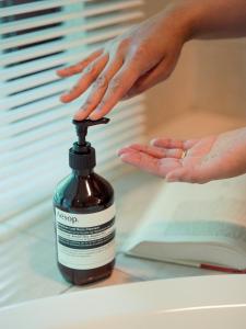 a person with their hand on a bottle of medication at Hotel La Neige in Hakuba