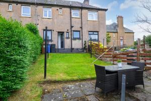 a yard with a table and chairs in front of a house at Sandyhill, St. Andrews in Fife