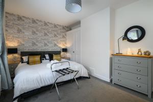 a bedroom with a bed and a chair in it at Sandyhill, St. Andrews in Fife