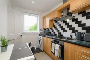 a kitchen with a black and white checkered wall at Sandyhill, St. Andrews in Fife
