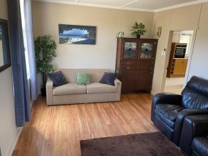 a living room with a couch and a chair at Jack's Tidal Pool Shack in Kingscote