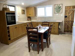 a kitchen with a table and chairs and a sink at Jack's Tidal Pool Shack in Kingscote
