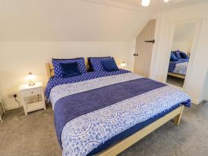 a bedroom with a large bed with blue pillows at The Cottage in Stratford-upon-Avon