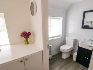 a white bathroom with a toilet and a sink at The Cottage in Stratford-upon-Avon +27 photos