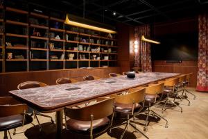 a long table in a room with chairs and books at Skald Hotel Akureyri, Curio Collection By Hilton in Akureyri