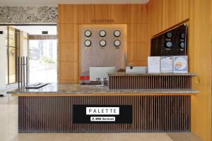 a lobby with a counter with clocks on the wall at Palette Mahbubabad Railway Station Formerly Hotel RC Platinum in Mahbūbābād
